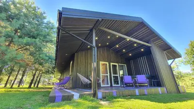 a small house with purple chairs on the porch at Violetinis namelis/ Sodyba Geras in Anykščiai