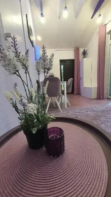 a round table with a vase with flowers on it at Violetinis namelis/ Sodyba Geras in Anykščiai