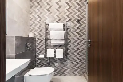 a bathroom with a toilet and a sink and towels at AN Hotel self check-in in Šiauliai