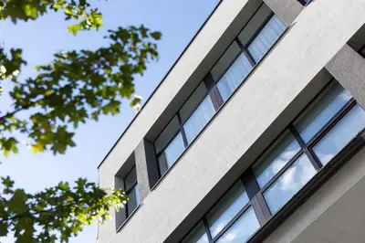 an office building with windows against a blue sky at AN Hotel self check-in in Šiauliai