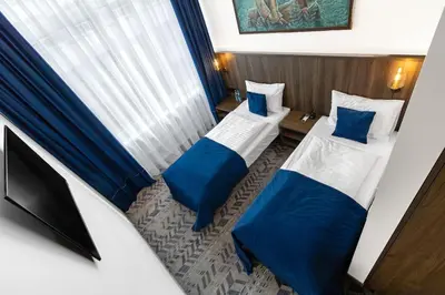 a room with two beds and a television in it at AN Hotel self check-in in Šiauliai