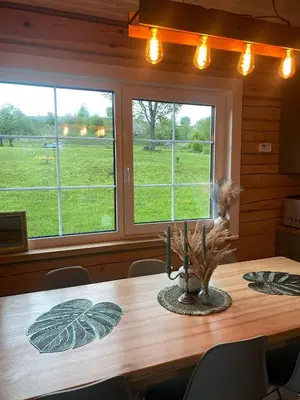 a dining room with a table and two windows at Sodyba vienkiemyje 