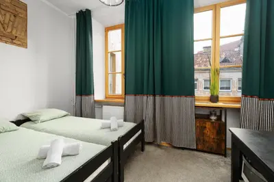 a bedroom with two beds and a window at Church through the window in Vilnius
