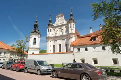 a group of cars parked in front of a church at Church through the window in Vilnius