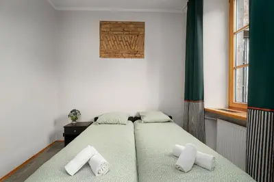 a bedroom with two beds and a window at Church through the window in Vilnius