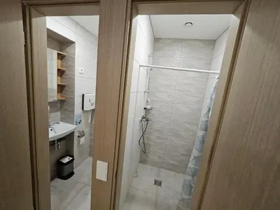 a bathroom with a walk in shower next to a sink at Kauno Apartamentai in Kaunas