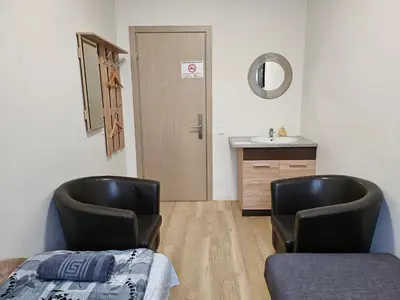 two chairs in a room with a sink and a bathroom at Kauno Apartamentai in Kaunas