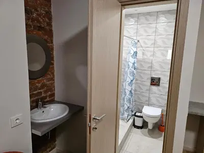 a bathroom with a sink and a toilet at Kauno apartamentai Big room king size bed in Kaunas