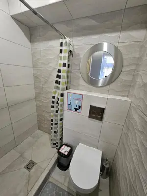a bathroom with a white toilet and a mirror at Kauno apartamentai Big room king size bed in Kaunas