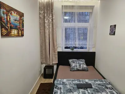 a small bedroom with a bed and a window at Kauno apartamentai Big bed in Kaunas