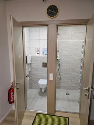 a bathroom with a toilet and a clock on the wall at Kauno apartamentai Big bed in Kaunas