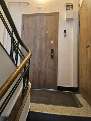 a wooden door in a building with a staircase at Kauno apartamentai Big bed in Kaunas