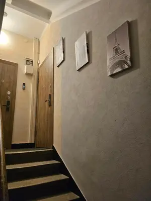 a hallway with stairs and pictures of the eiffel tower at Kauno apartamentai big bed in Kaunas