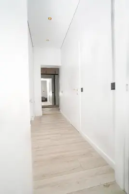 an empty hallway with white walls and wood floors at Old Town apartment in Kaunas
