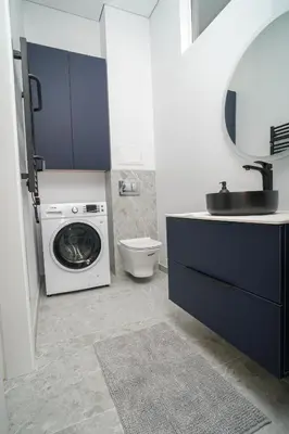 a bathroom with a washing machine and a sink at Old Town apartment in Kaunas