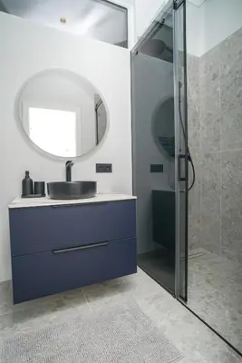 a bathroom with a sink and a glass shower at Old Town apartment in Kaunas