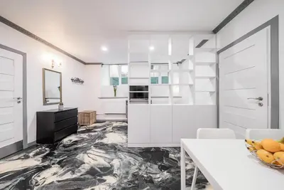 a kitchen with white cabinets and a marble floor at Klaipedos Apartment - Lollo Stay in Vilnius