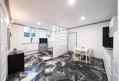a kitchen with white cabinets and a black marble floor at Klaipedos Apartment - Lollo Stay in Vilnius