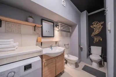 a bathroom with a sink and a toilet and a mirror at Klaipedos Apartment - Lollo Stay in Vilnius
