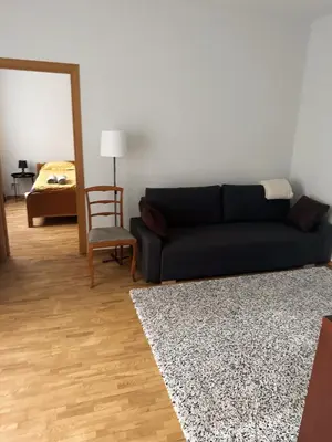 a living room with a black couch and a mirror at City Center Apartments in Vilnius