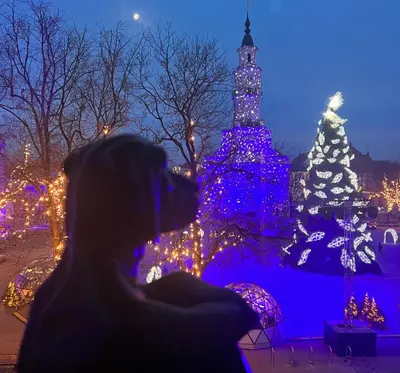 a woman taking a picture of a christmas light display at KAUNAS ATTIC, Apartment in the heart of Kaunas in Kaunas