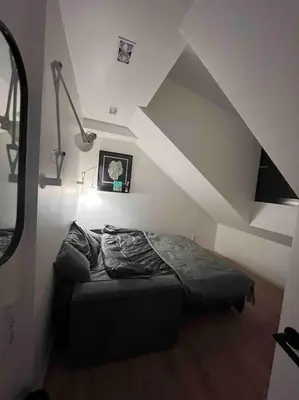 a bed sitting in a room with a attic at KAUNAS ATTIC, Apartment in the heart of Kaunas in Kaunas