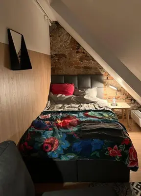 a bedroom with a bed with a floral blanket at KAUNAS ATTIC, Apartment in the heart of Kaunas in Kaunas