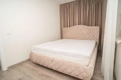 a bed in a room with a pink chair at Oldtown art apartaments in Kaunas