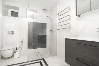 a white bathroom with a shower and a toilet at Oldtown art apartaments in Kaunas