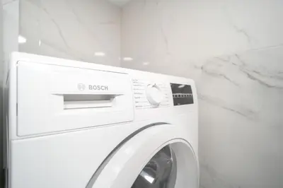 a white washing machine in a white room at Oldtown art apartaments in Kaunas