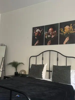 a bedroom with a black bed with flowers on the wall at Modern city centre apartment in Vilnius