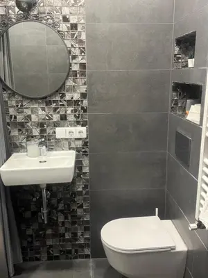 a bathroom with a toilet and a sink and a mirror at Modern city centre apartment in Vilnius