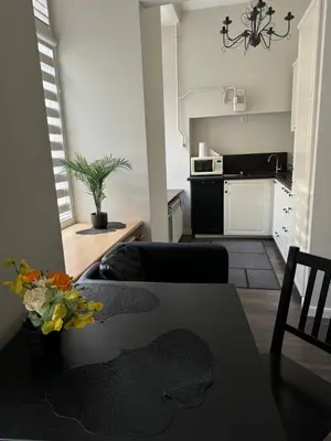 a living room with a table and a kitchen at Modern city centre apartment in Vilnius
