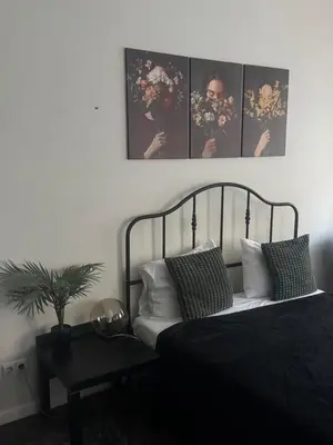 a bedroom with a bed with four pictures on the wall at Modern city centre apartment in Vilnius