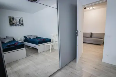 a room with a mirror and a bed and a couch at Ramūs apartamentai in Anykščiai