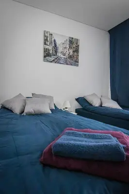 a bedroom with two beds and a picture on the wall at Ramūs apartamentai in Anykščiai