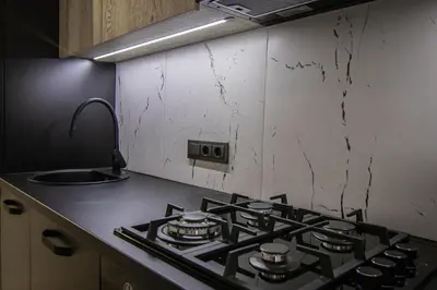 a kitchen with a stove top oven in a kitchen at Ramūs apartamentai in Anykščiai