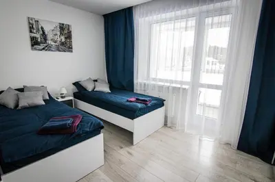 a bedroom with two beds and a window at Ramūs apartamentai in Anykščiai