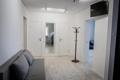 a living room with a couch and a flat screen tv at Ramūs apartamentai in Anykščiai