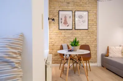 a table and chairs in a room with a brick wall at Lukiskes square apartment (Oldtown) in Vilnius