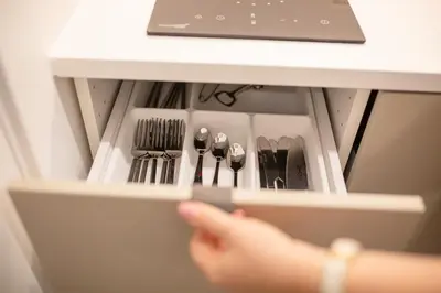 a person is reaching into a drawer of a refrigerator at Lukiskes square apartment (Oldtown) in Vilnius