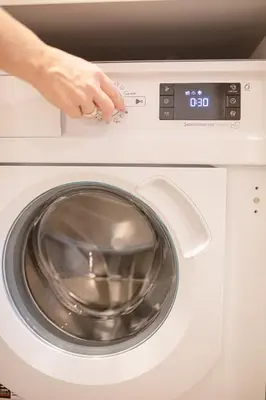 a person is standing next to a washing machine at Lukiskes square apartment (Oldtown) in Vilnius