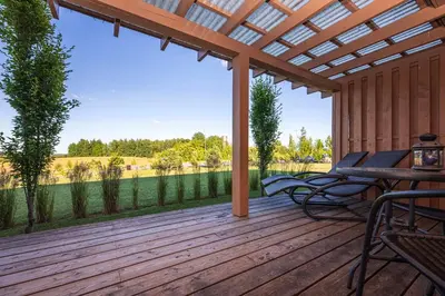 a patio with a table and chairs on a wooden deck at Gradiali Anykščiai in Anykščiai