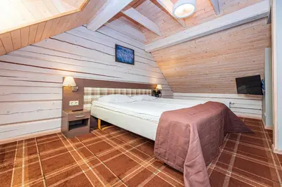 a bedroom with a bed in a wooden room at Gradiali Anykščiai in Anykščiai