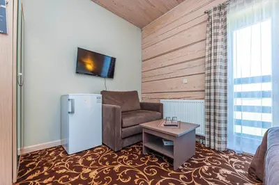 a living room with a couch and a chair and a table at Gradiali Anykščiai in Anykščiai