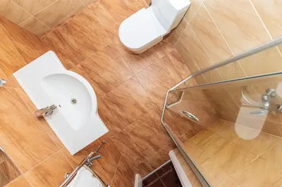 a bathroom with a toilet and a glass shower stall at Gradiali Anykščiai in Anykščiai