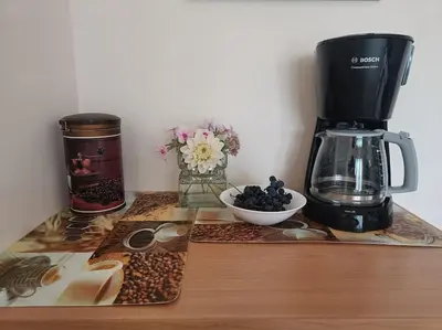 a counter with a coffee maker and a bowl of coffee beans at Spacious Apartment Panemune in Kaunas