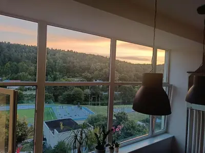 a room with a window with a view of a tennis court at River Vilnele View Studio in Vilnius