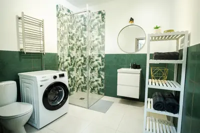 a bathroom with a washing machine and a shower at Central Station Apartment No1 in Kaunas
