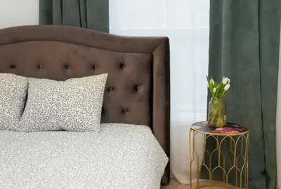 a bed with a vase of flowers on a table at Central Station Apartment No1 in Kaunas